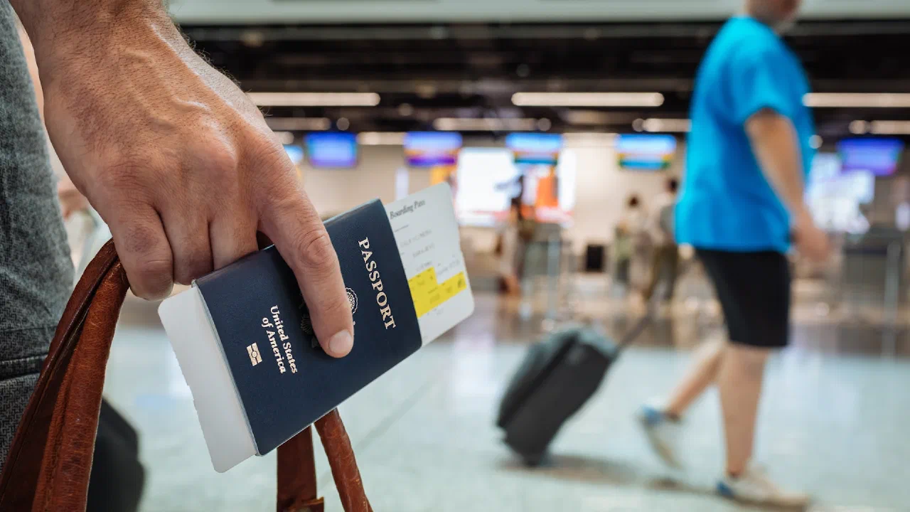 A hand holding an open passport booklet
